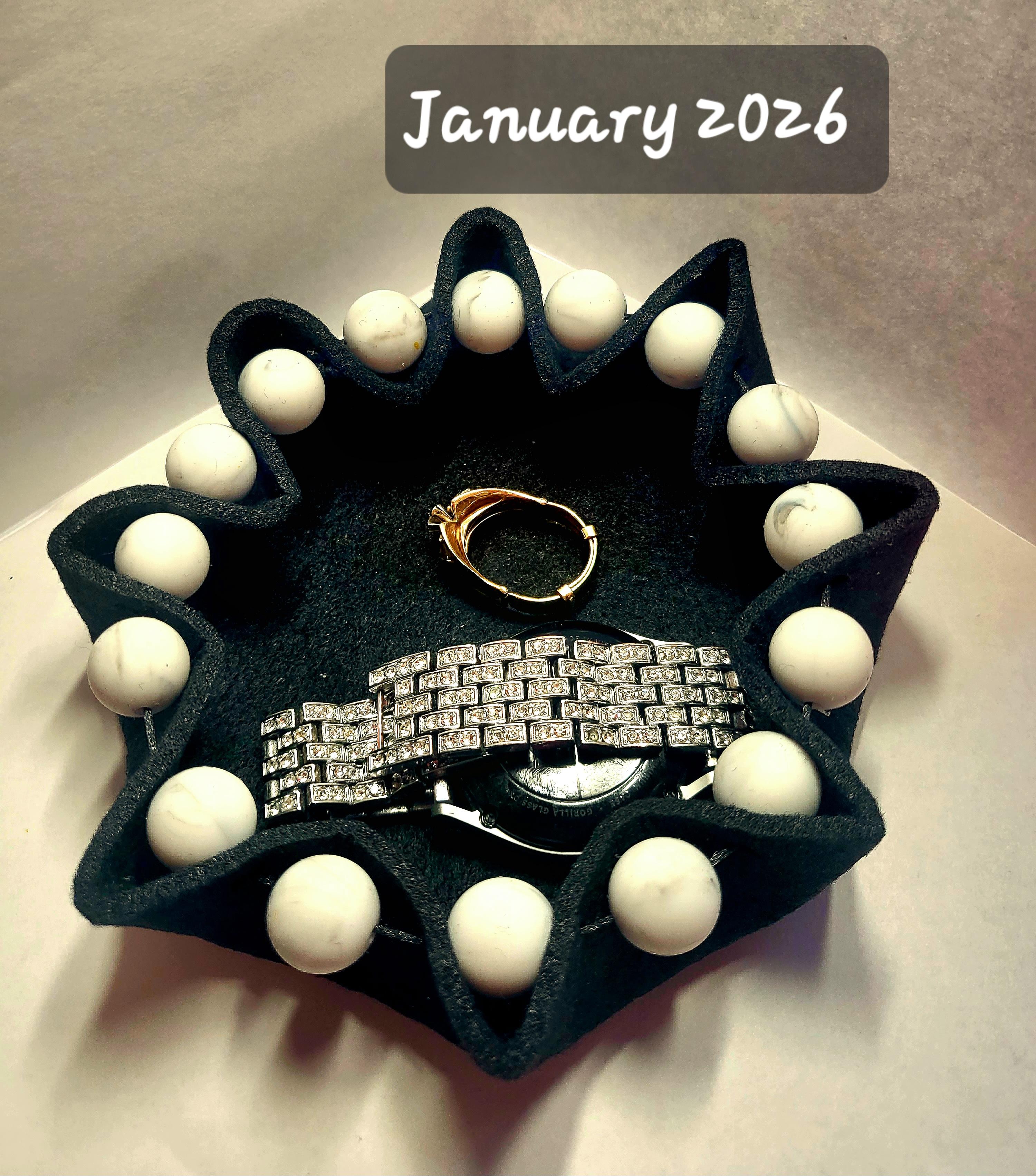 green felt bowl with white beads watch and ring in bowl